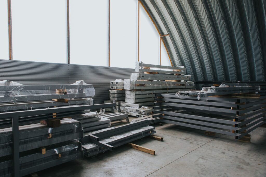 Bright interior of a sheet metal fabrication facility with stacked metal components and materials, showcasing precision-crafted parts for HVAC and industrial applications.